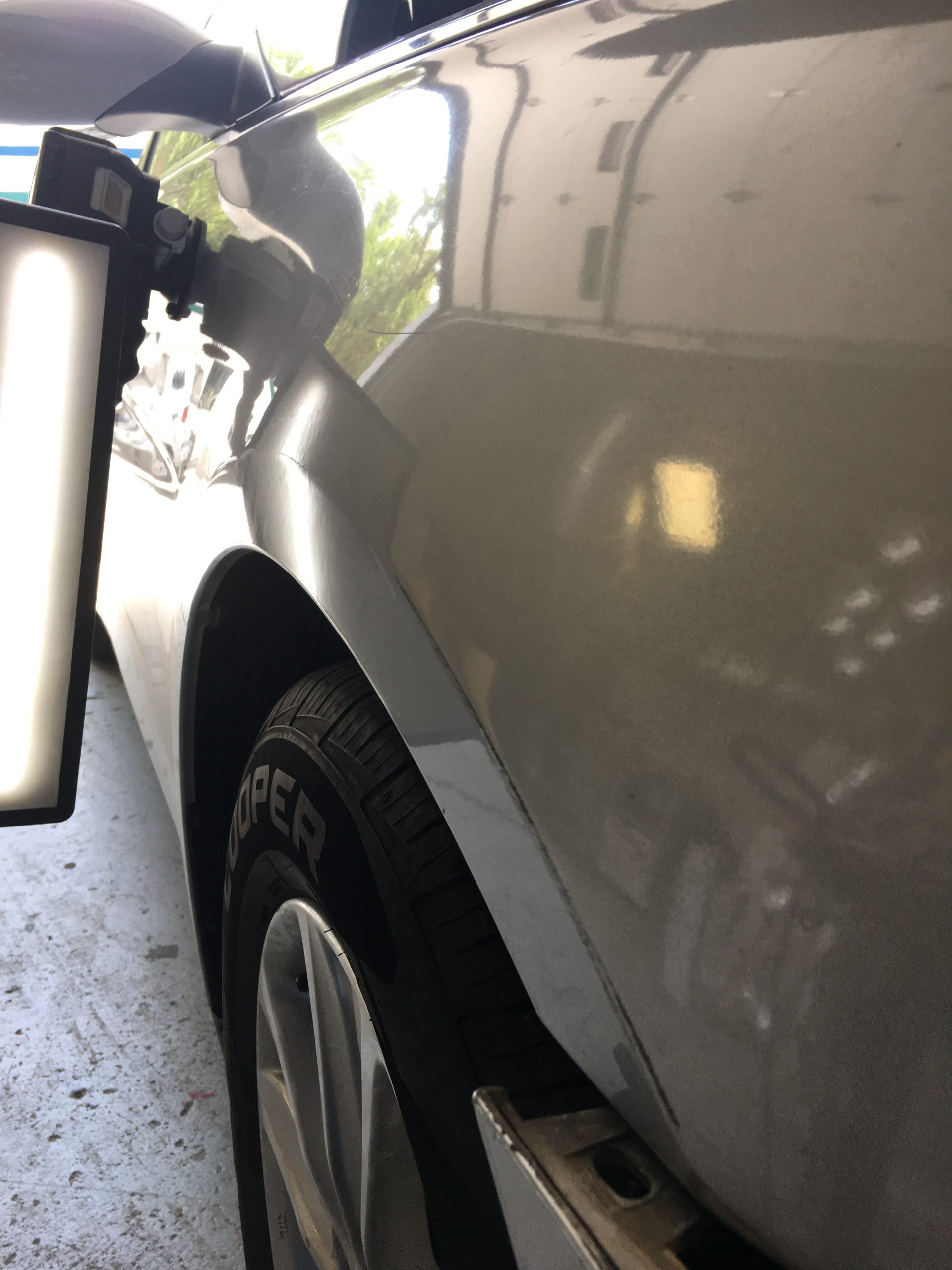 A vehicle panel restored to a clean reflection after paintless dent repair by Premier PDR